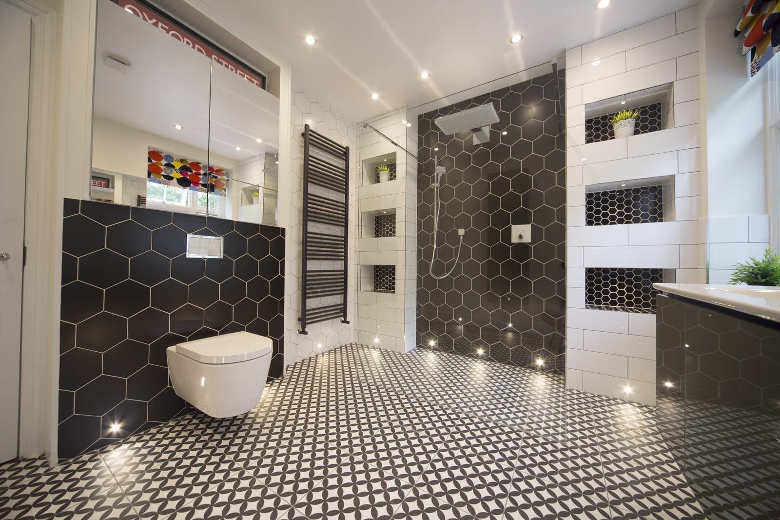 Walk-in shower with black hexagonal tiles installed by The Wetherby Plumber